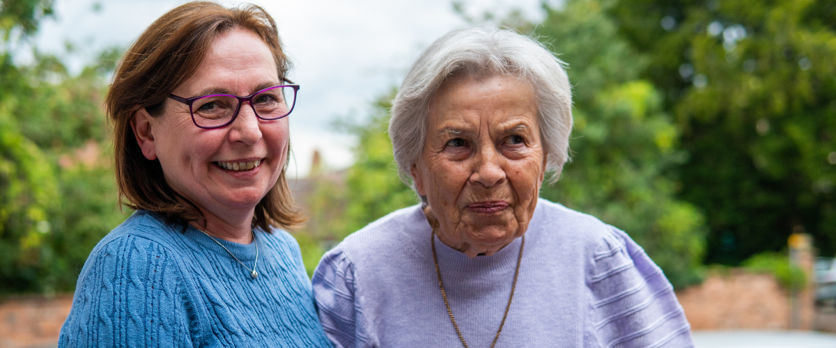 two woman outside smiling to camera