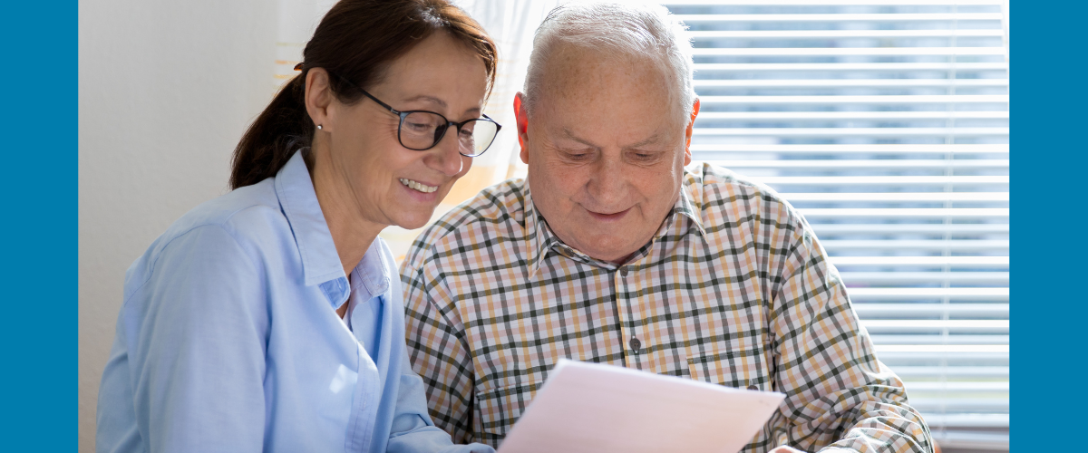 an older man looking at paperwork with a younger woman